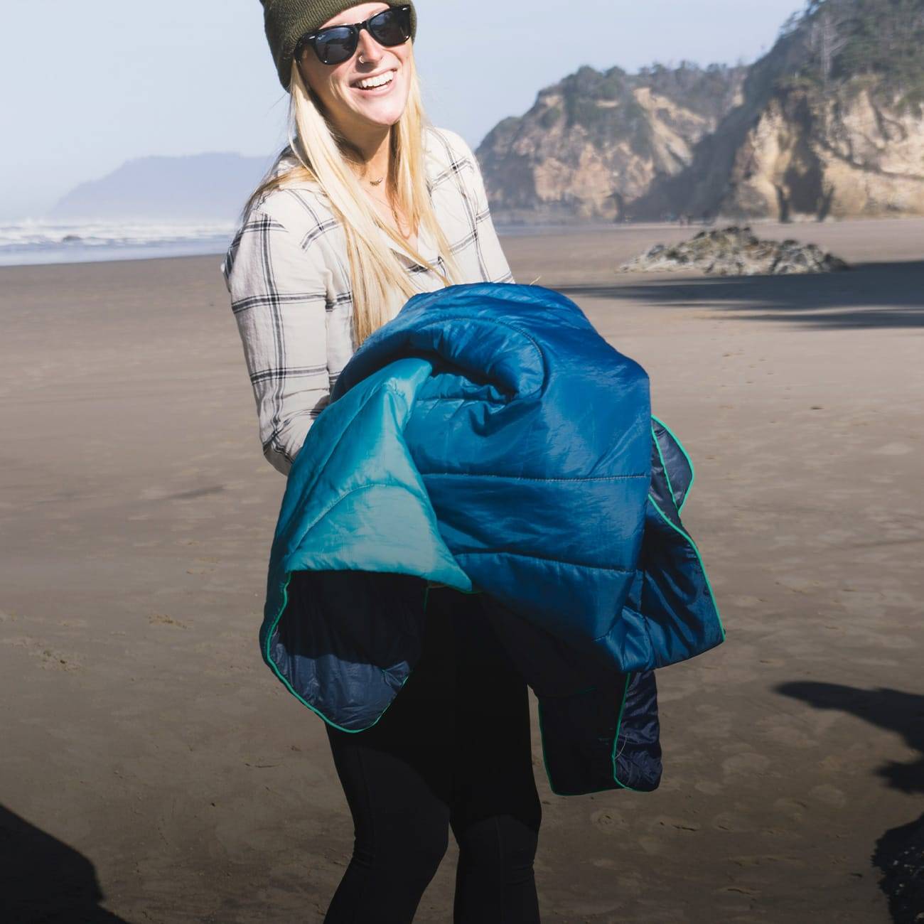 Woman walking on beach holding Original Puffy Blanket