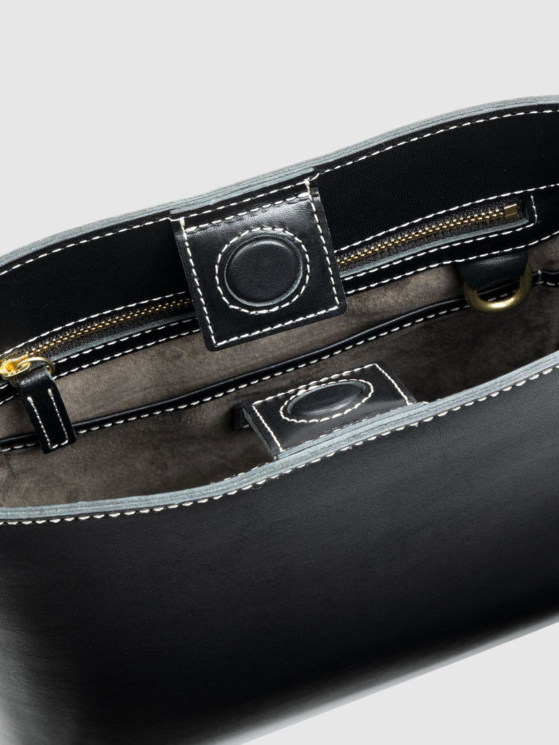 Interior view of a black leather bag with pockets and zippers.