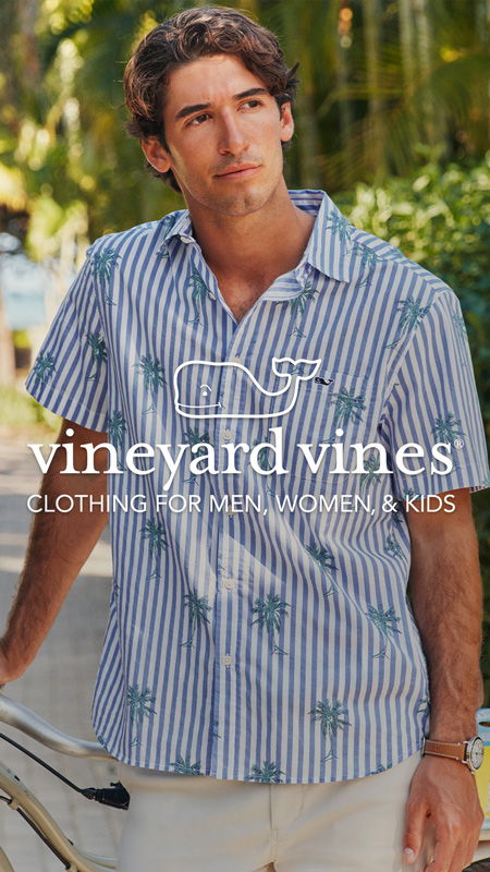 A man in a striped shirt poses outdoors.