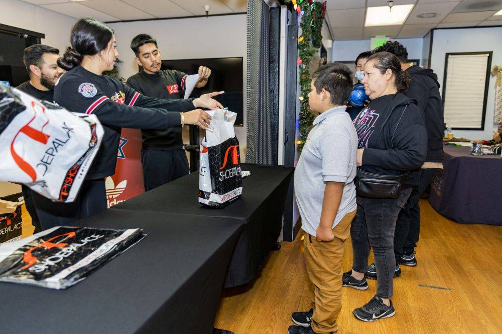 employees help out a customer at sp x adidas christmas party 2
