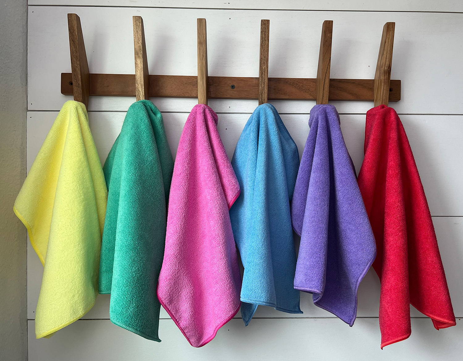 different colored microfiber towels hanging on rack