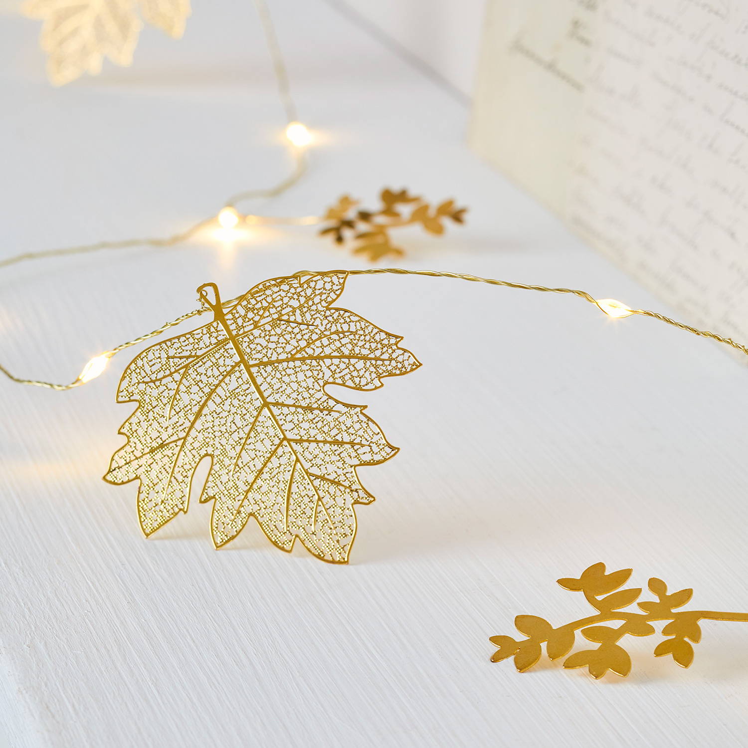 A close up of gold leaf micro lights on a shelf.
