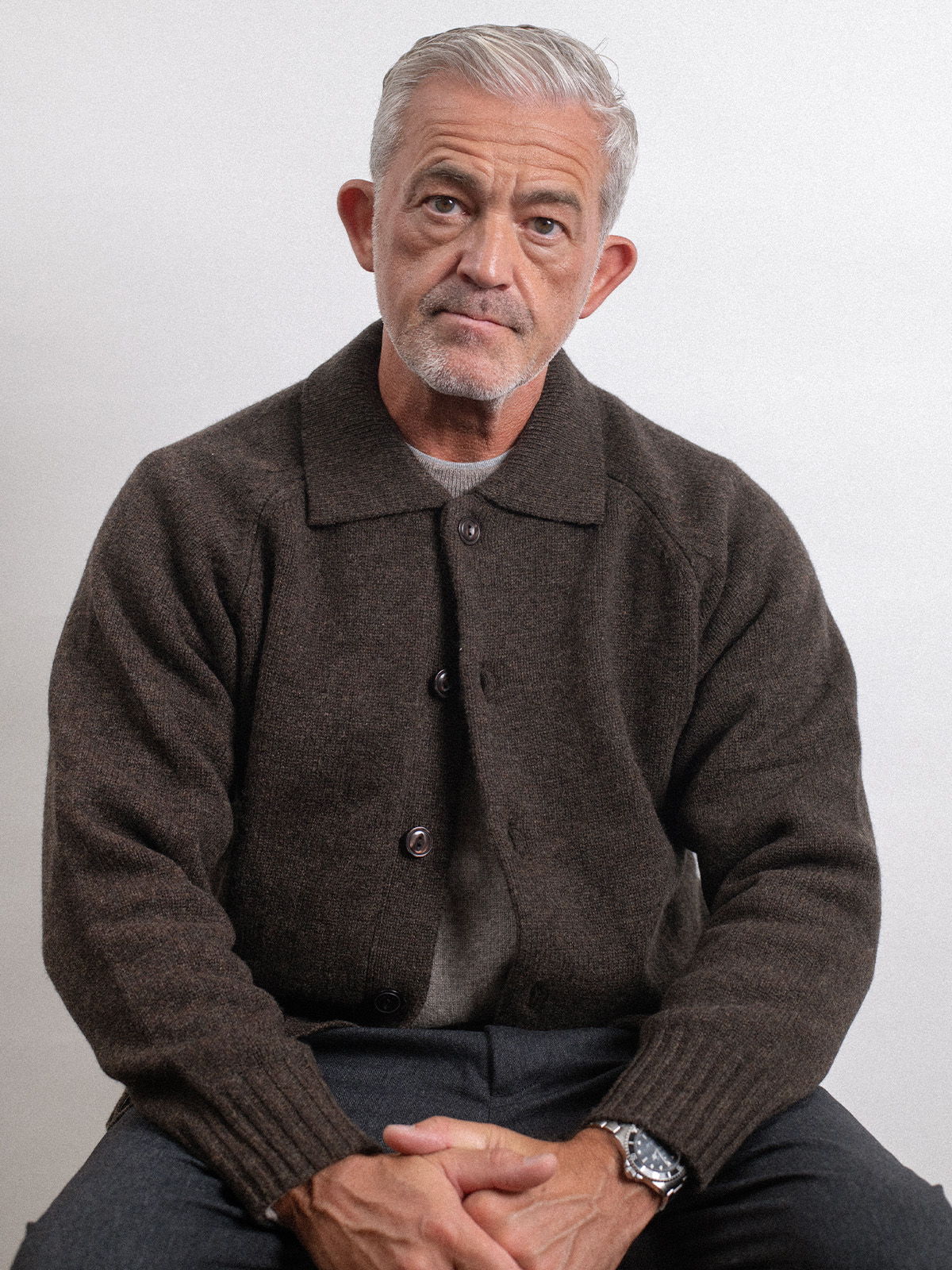 Rob in a brown sweater sitting against a plain background.