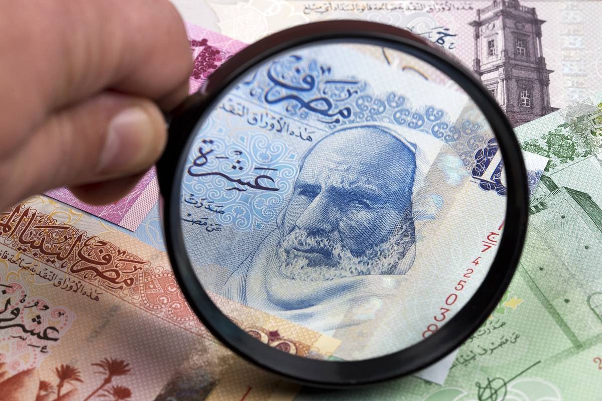 Magnifying glass held up to a Libyan Dinar 