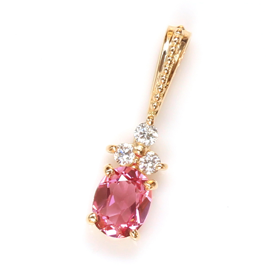 Gold pendant featuring a pink gemstone and three small diamonds.