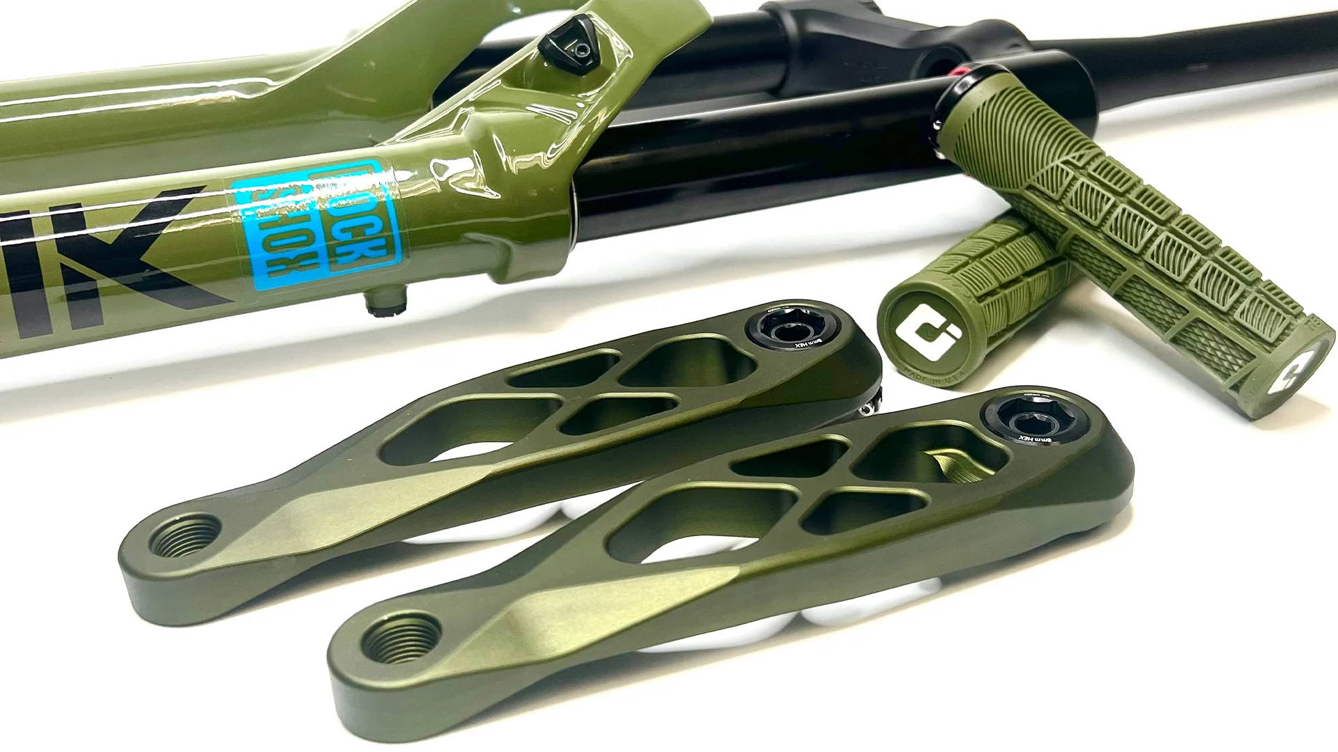 Green 5DEV aluminum crank arms next to a RockShox Lyrik and green ODI grips