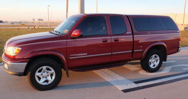 Maroon first-generation Toyota Tundra Access Cab with color-matched camper shell black side steps chrome bumper and alloy wheels parked on asphalt at golden hour Dennis's Nathan Airchime K5 train horn featured customer install gallery photo 1