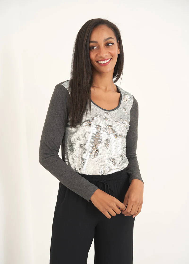 A model wearing a silver sequin top with grey jersey sleeves 