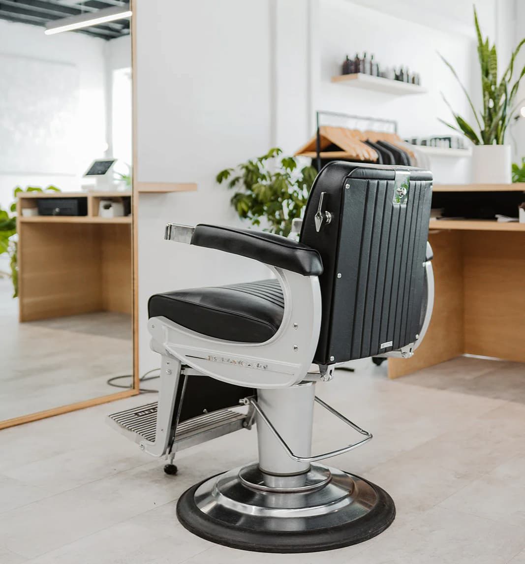 Brightly lit barbershop with plants and a barber chair