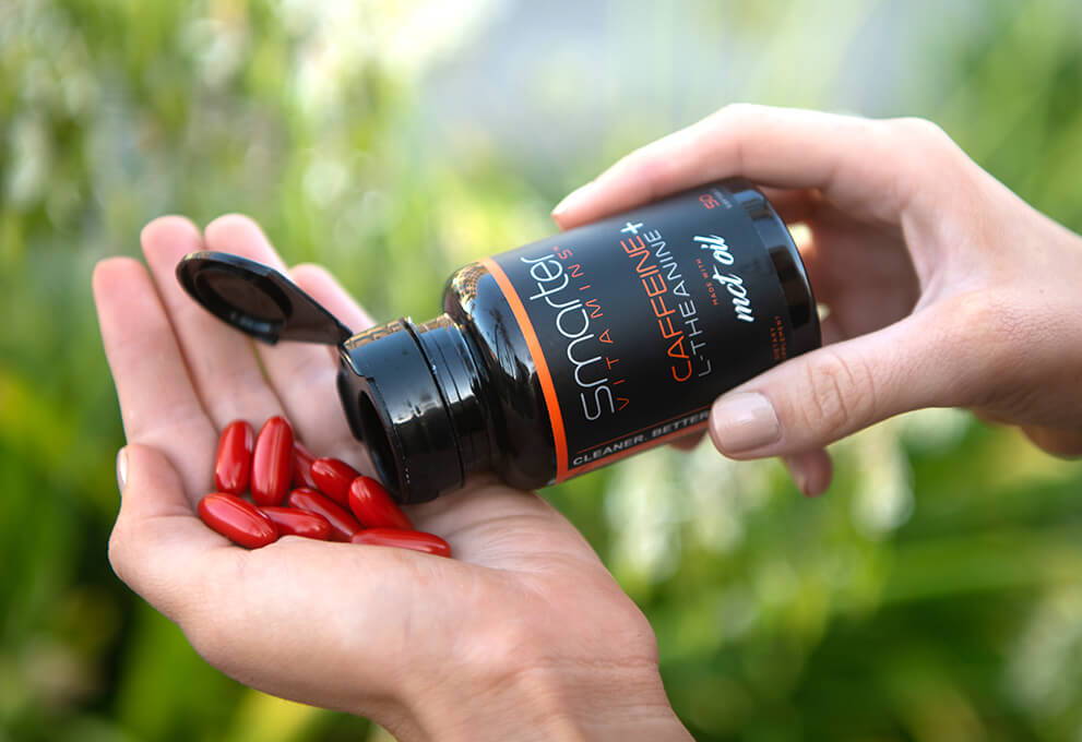 Opened Caffeine plus L-Theanine bottle in hand, pouring vitamins into other hand.