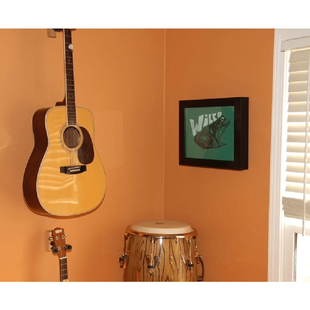 Wilco Concert t-shirt displayed in a Shart Premium Square T-Shirt Frame next to a drum and guitar