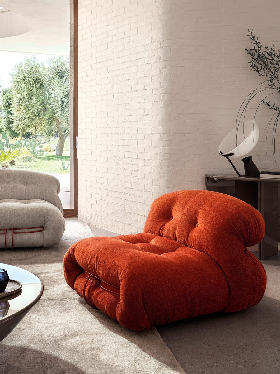 A modern orange chair in a stylish, bright living room setting.