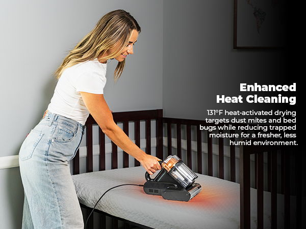 Woman using a mattress vacuum on a crib mattress. Text about enhanced heat cleaning.