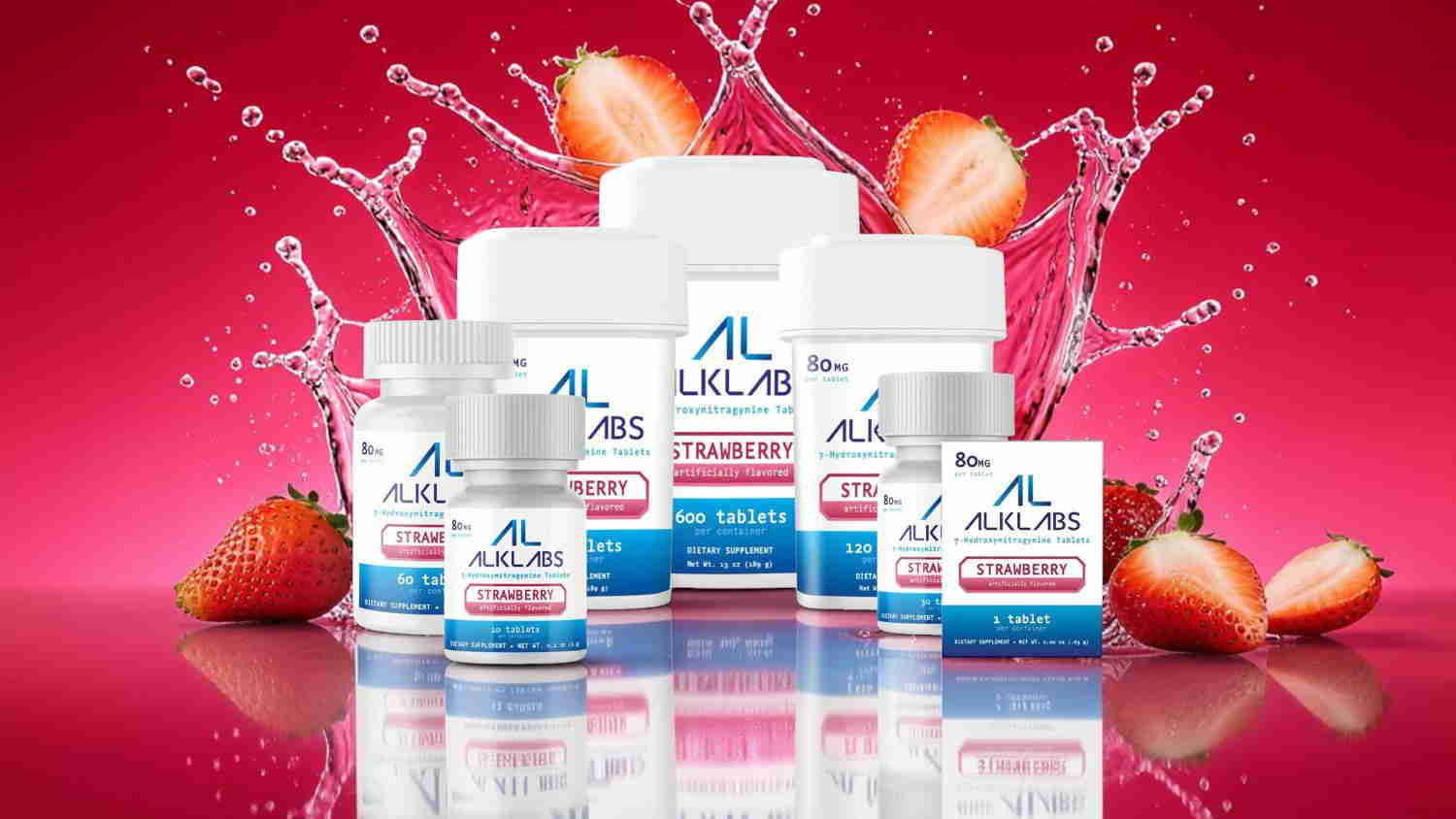Bottles of dietary supplements with strawberries and splashes on a pink background.