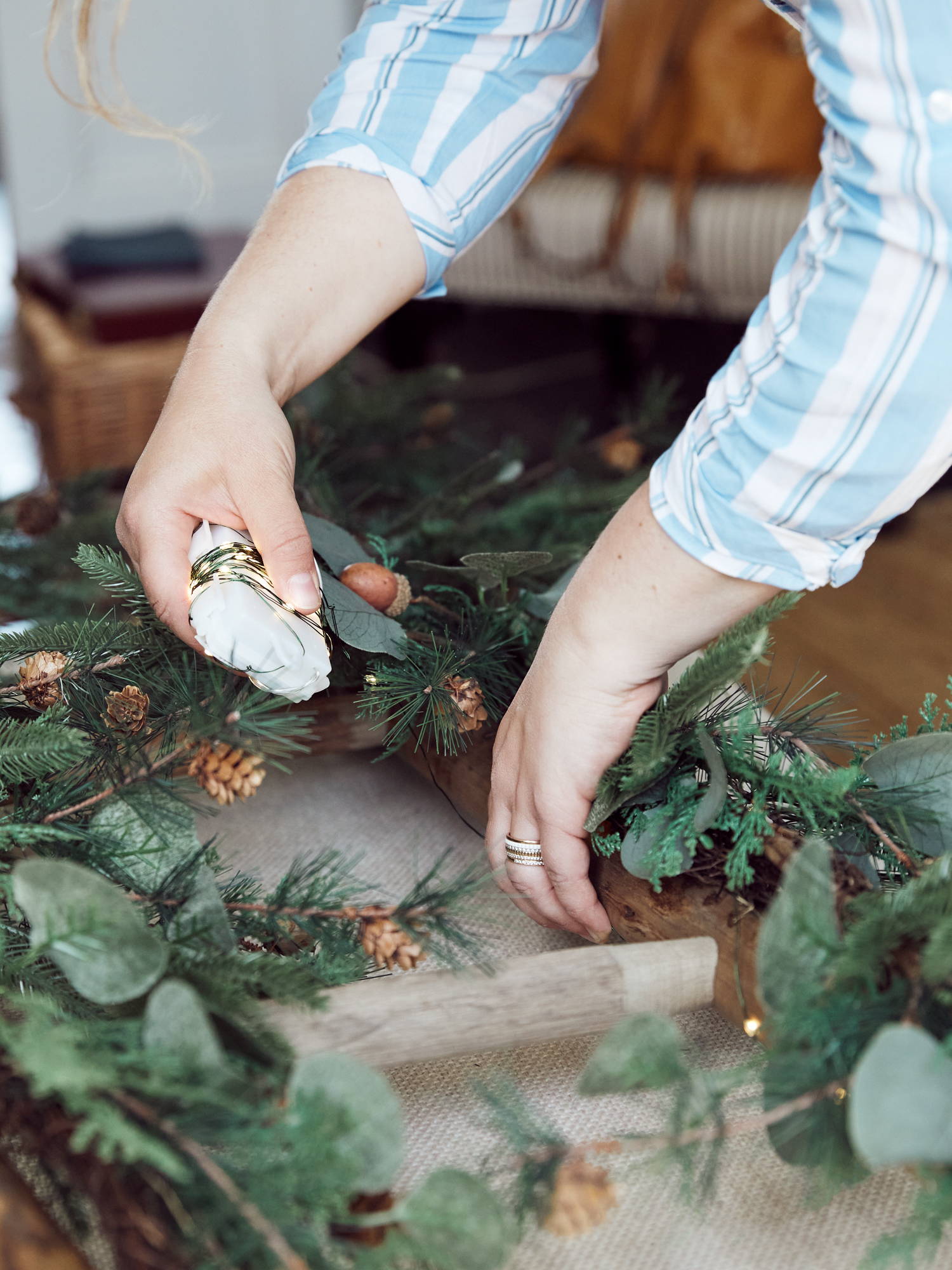 Person entwining micro lights the ladder and garland.