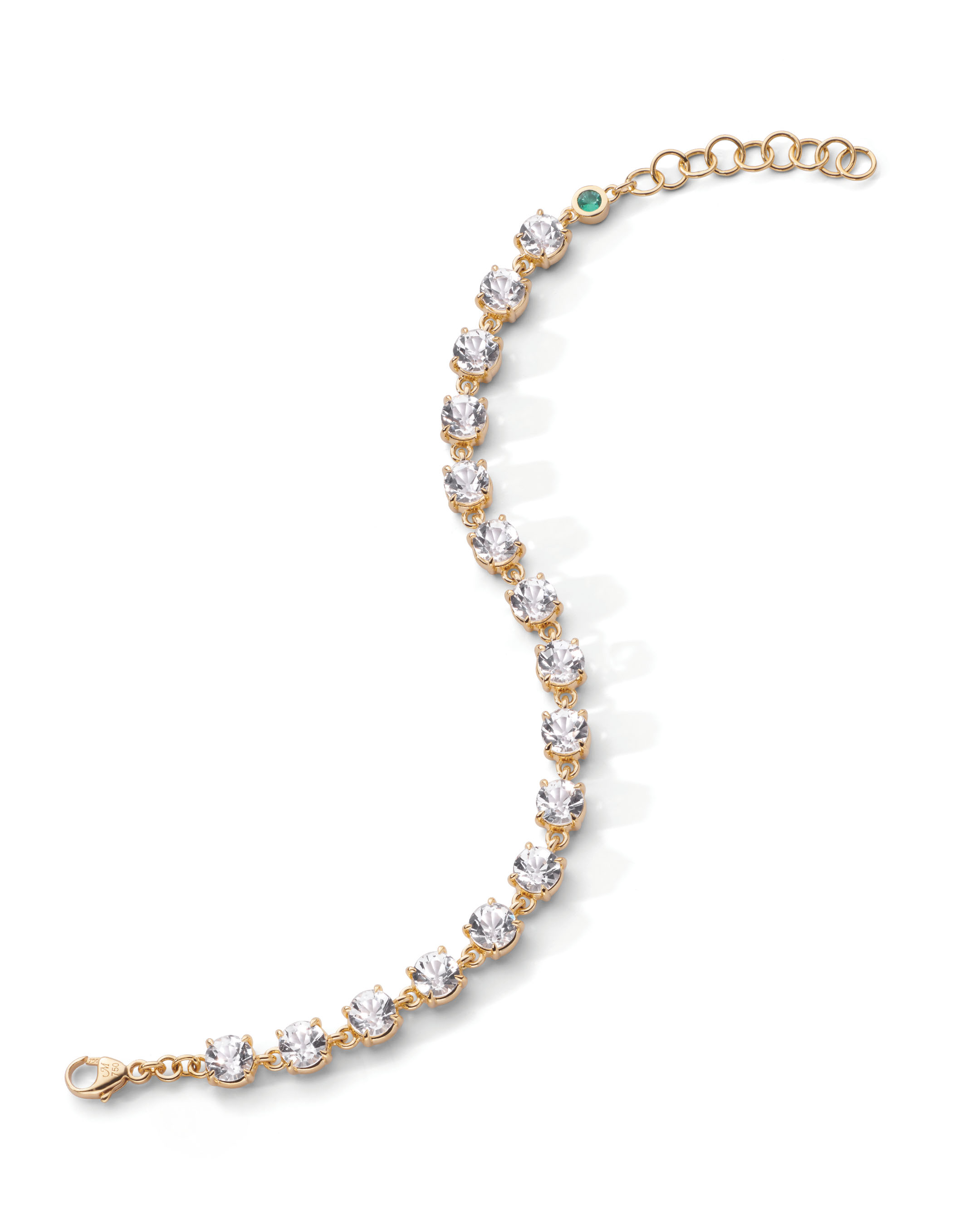 Gold bracelet with sparkling stones and a green accent.