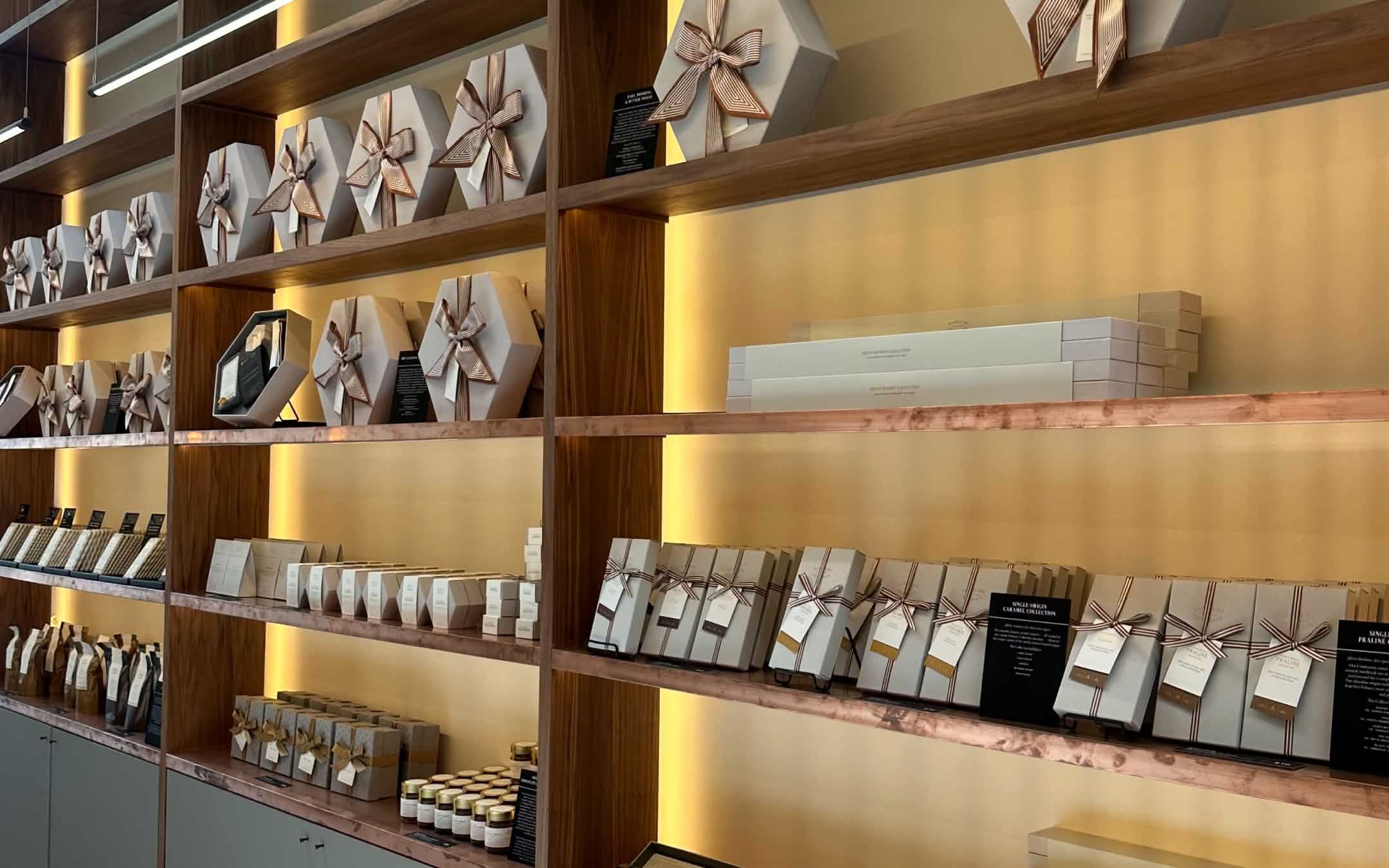 A display of neatly arranged packaged items on wooden shelves.