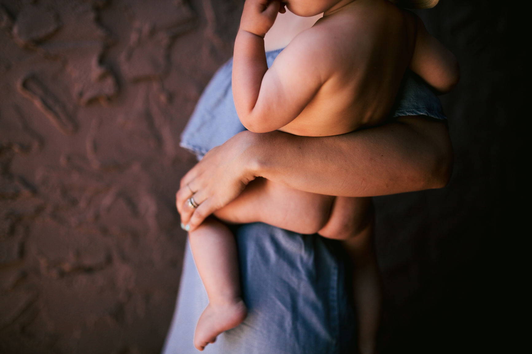 Mom holding naked baby on her hip
