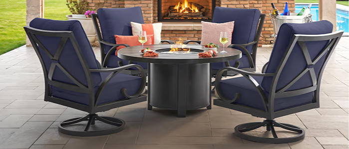 Outdoor seating area with a fireplace and television in a cozy setting.