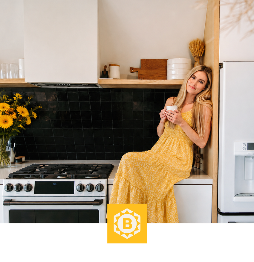 Woman in a yellow dress sitting on a kitchen counter with flowers.