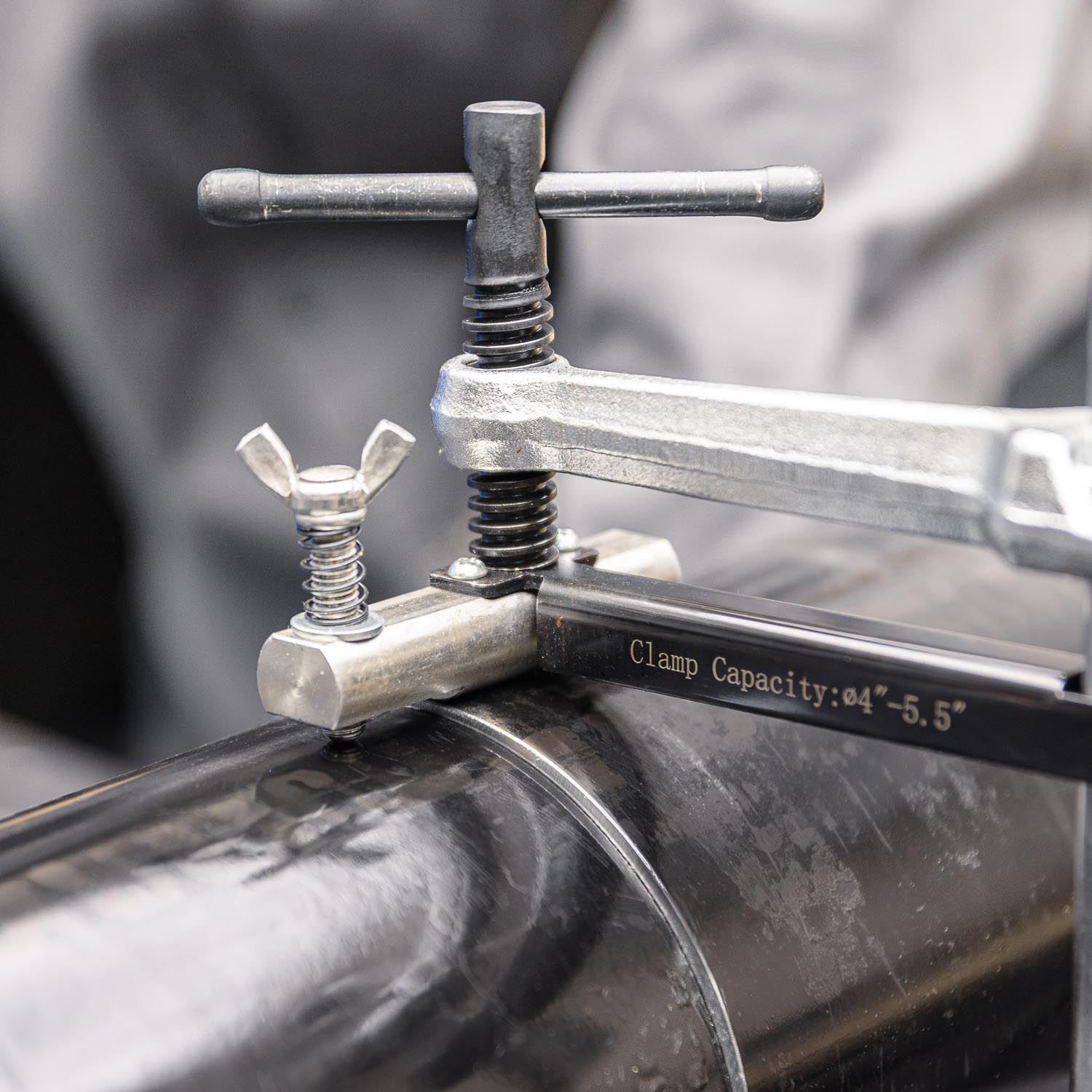 Pipe clamp tool being used on a black pipe.