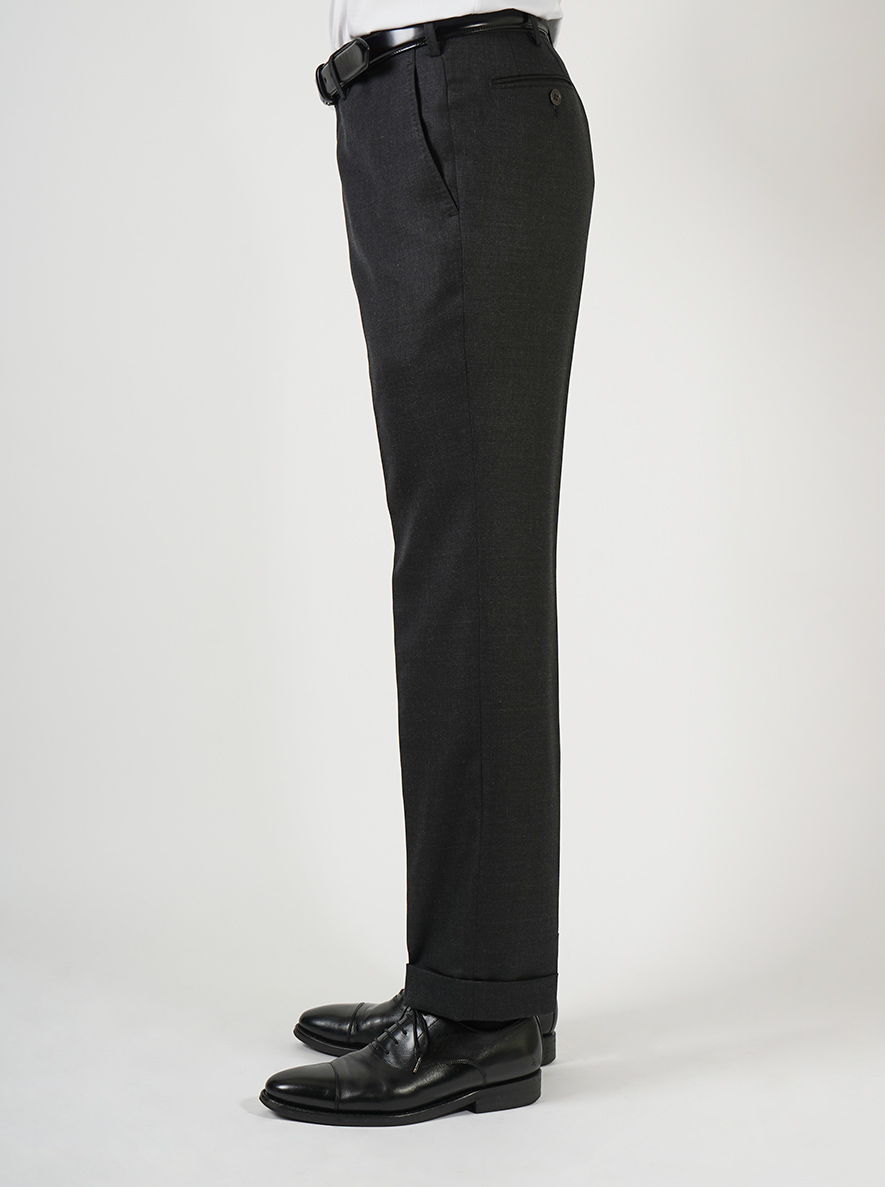 Side view of black dress pants and black shoes on a model.