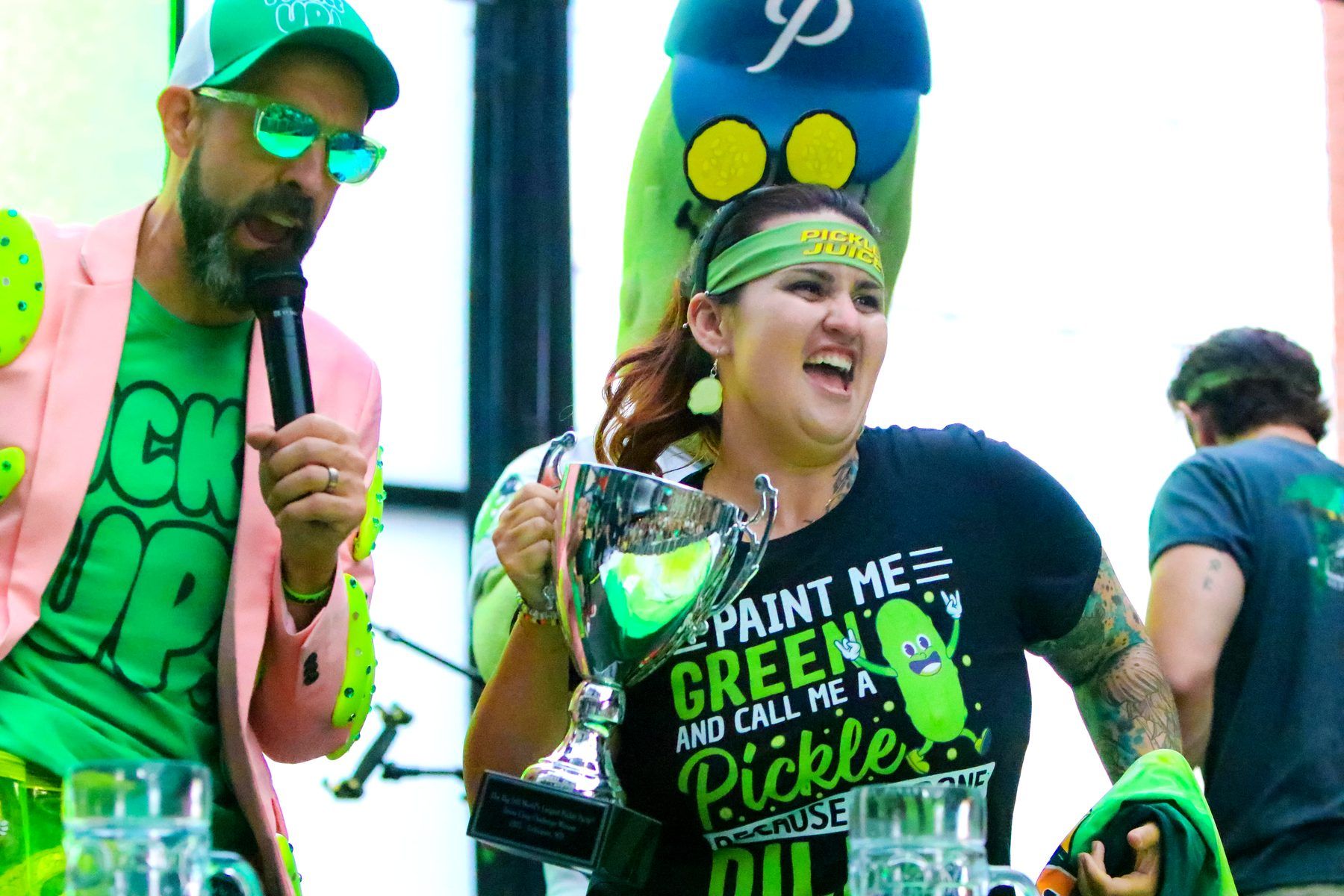 Brine Chug Challenge winner celebrating with her trophy on stage at The Big Dill Baltimore 2025.