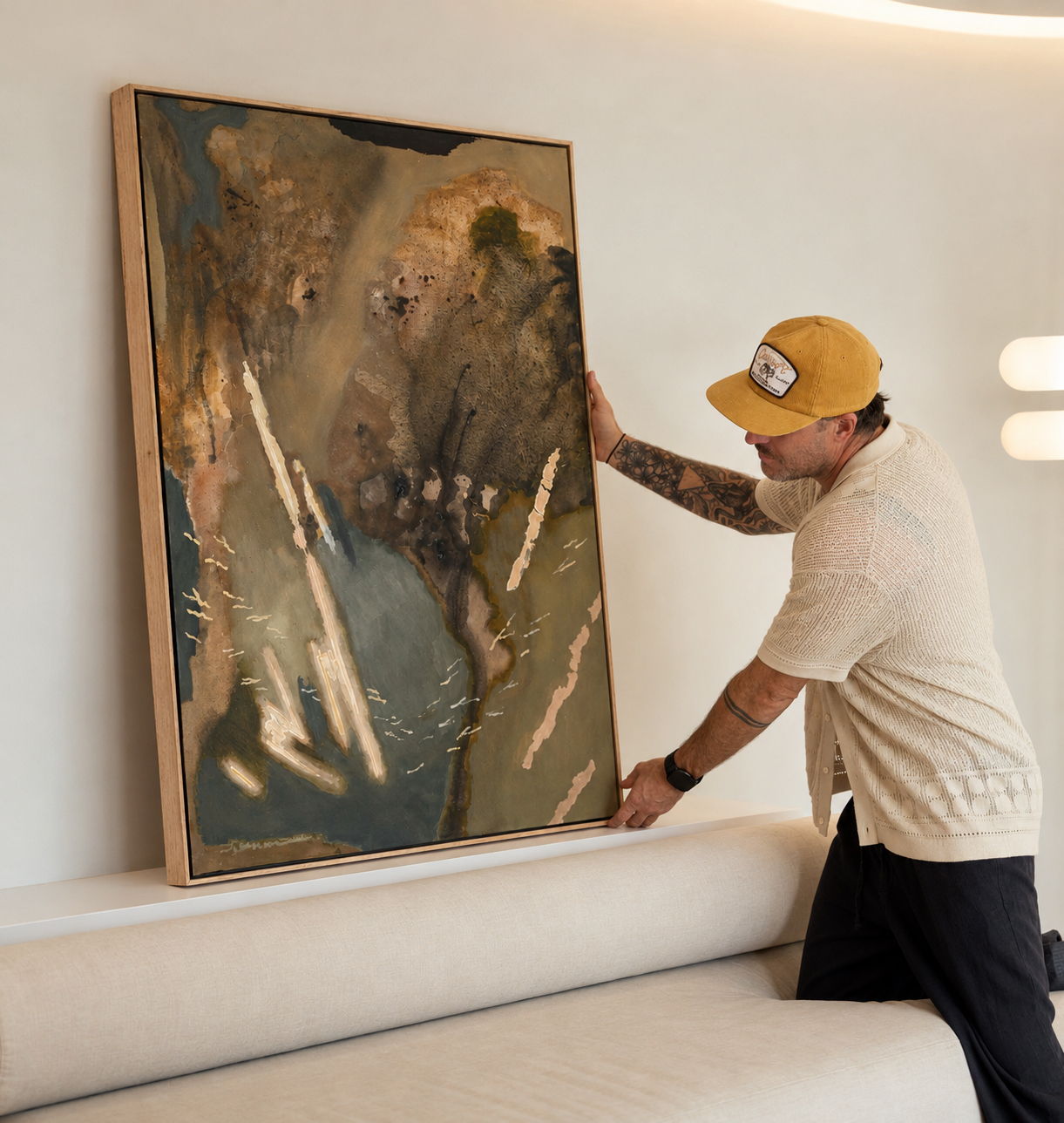Stephen Skinner adjusting his 'Liminal' abstract painting on Lighting Collective's showroom in Byron Bay..