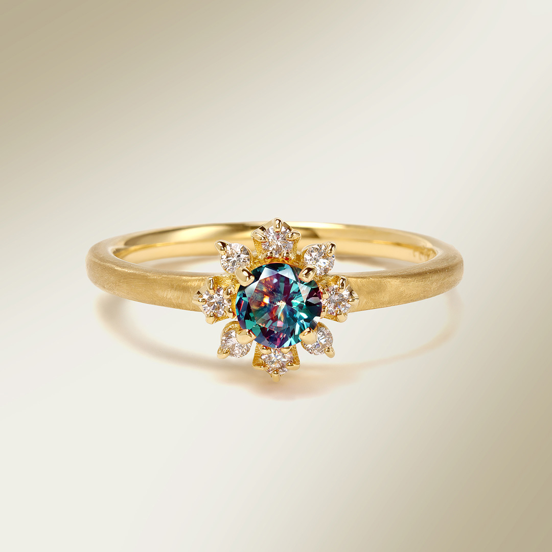 Gold ring with a colorful gemstone and diamond accents.