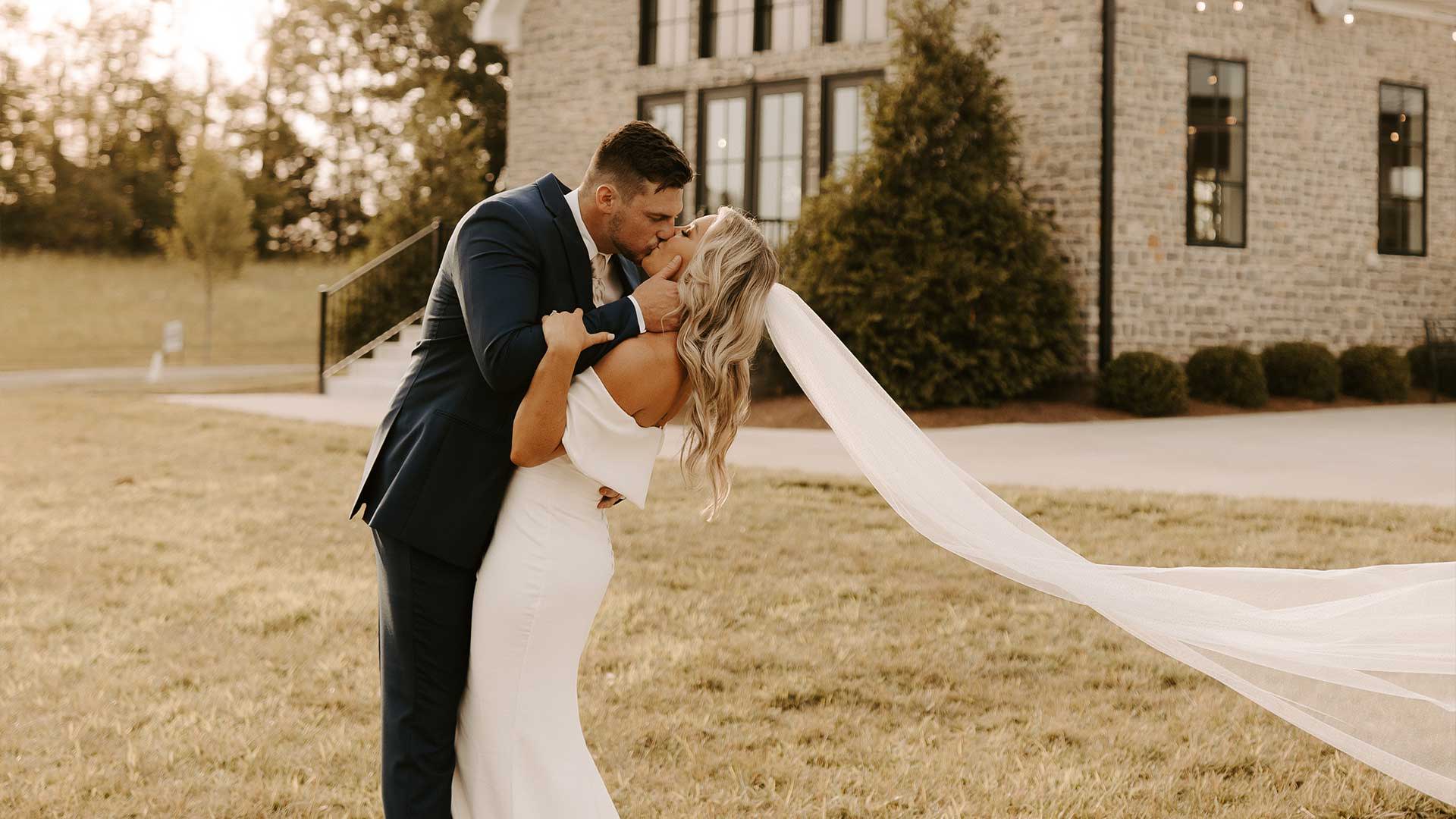 Bride and groom sharing a kiss in front of wedding chapel