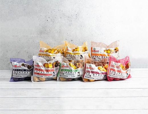Assorted bags of snacks arranged on a white wooden surface.