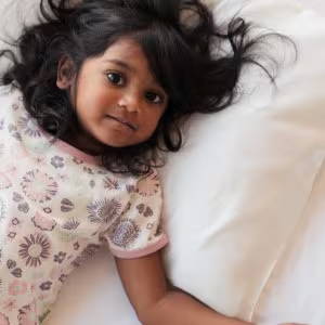 toddler girl lying on silk pillowcase
