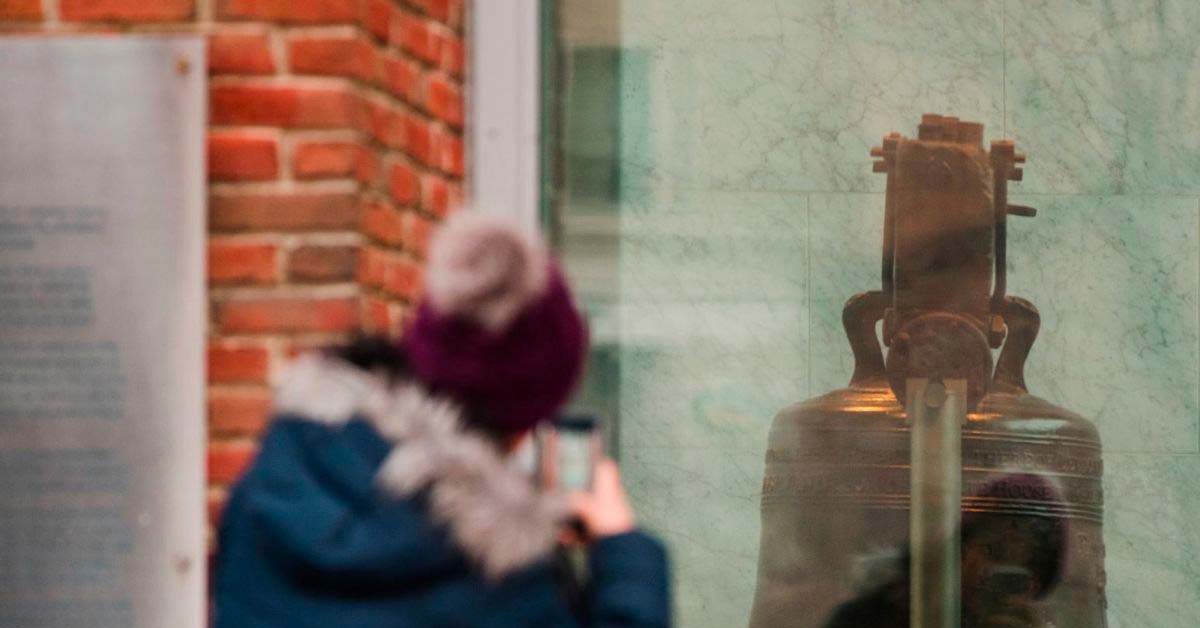 Person taking picture of a reflection of a bell