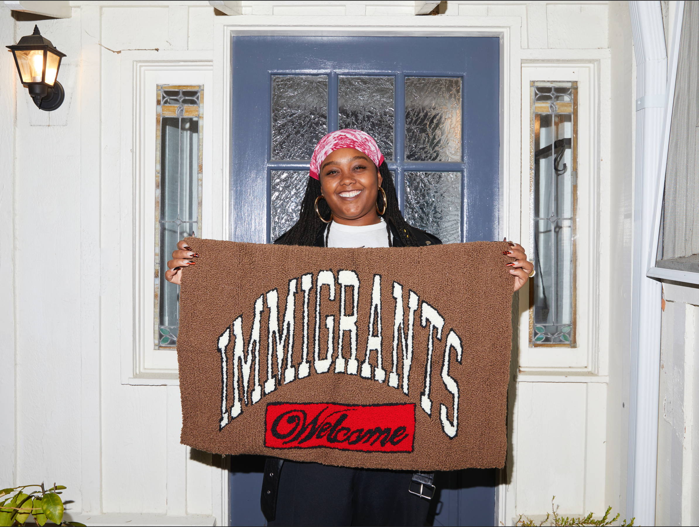 Woman holding Kids of Immigrants immigrants welcome mat