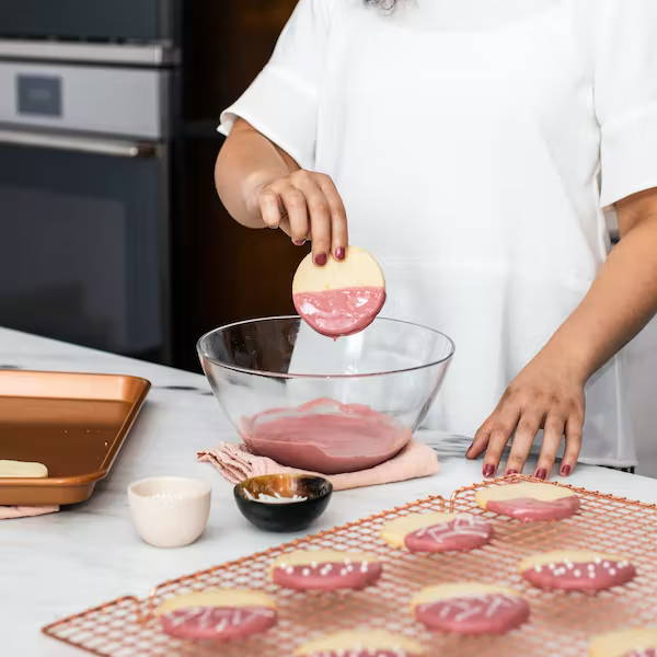 Dipping shortbread cookie into melted ruby chocolate