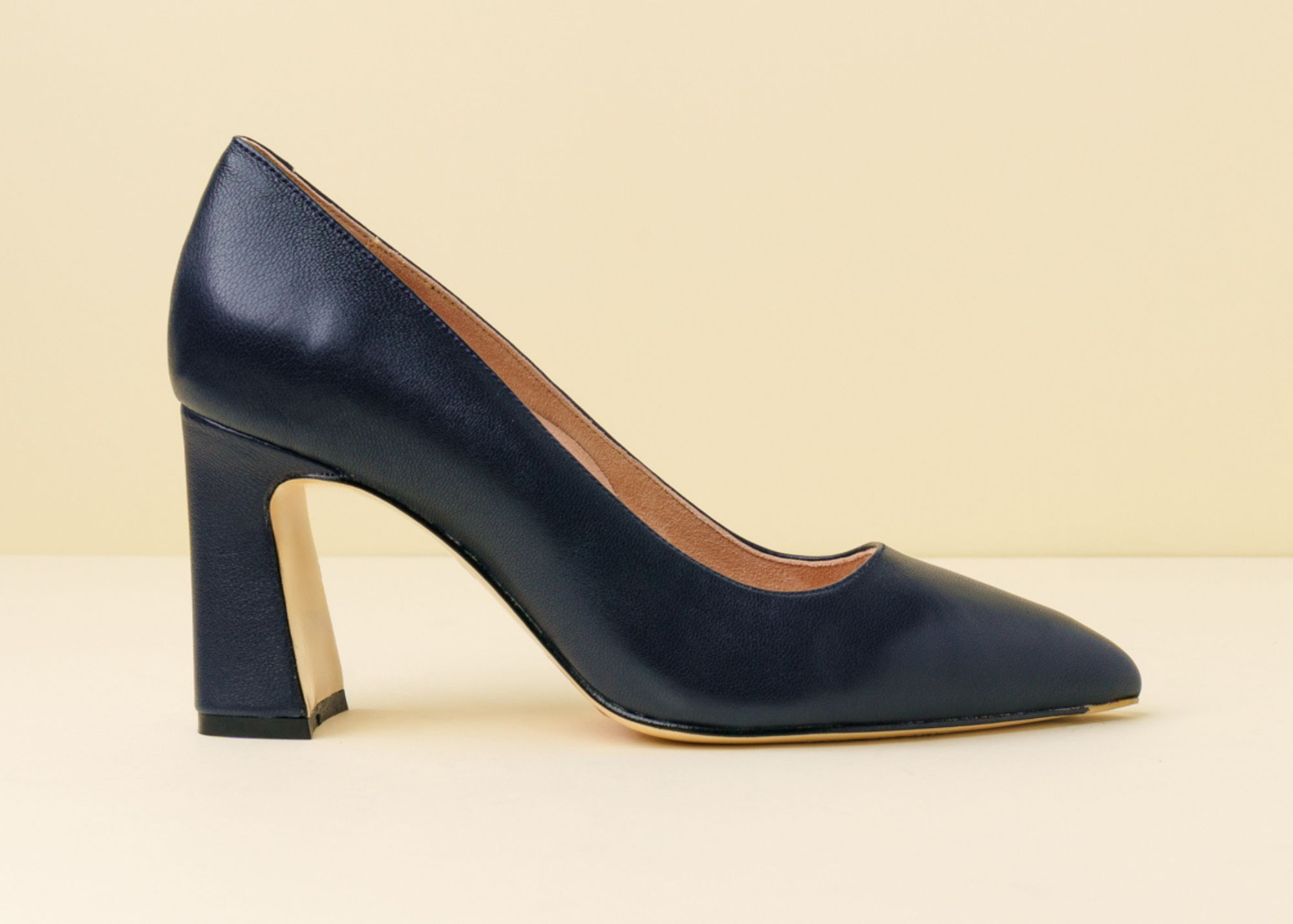 A navy high-heeled shoe with a chunky heel on a light background.