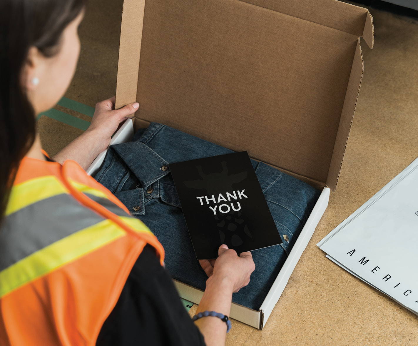 Warehouse employee putting a thank you card in an order