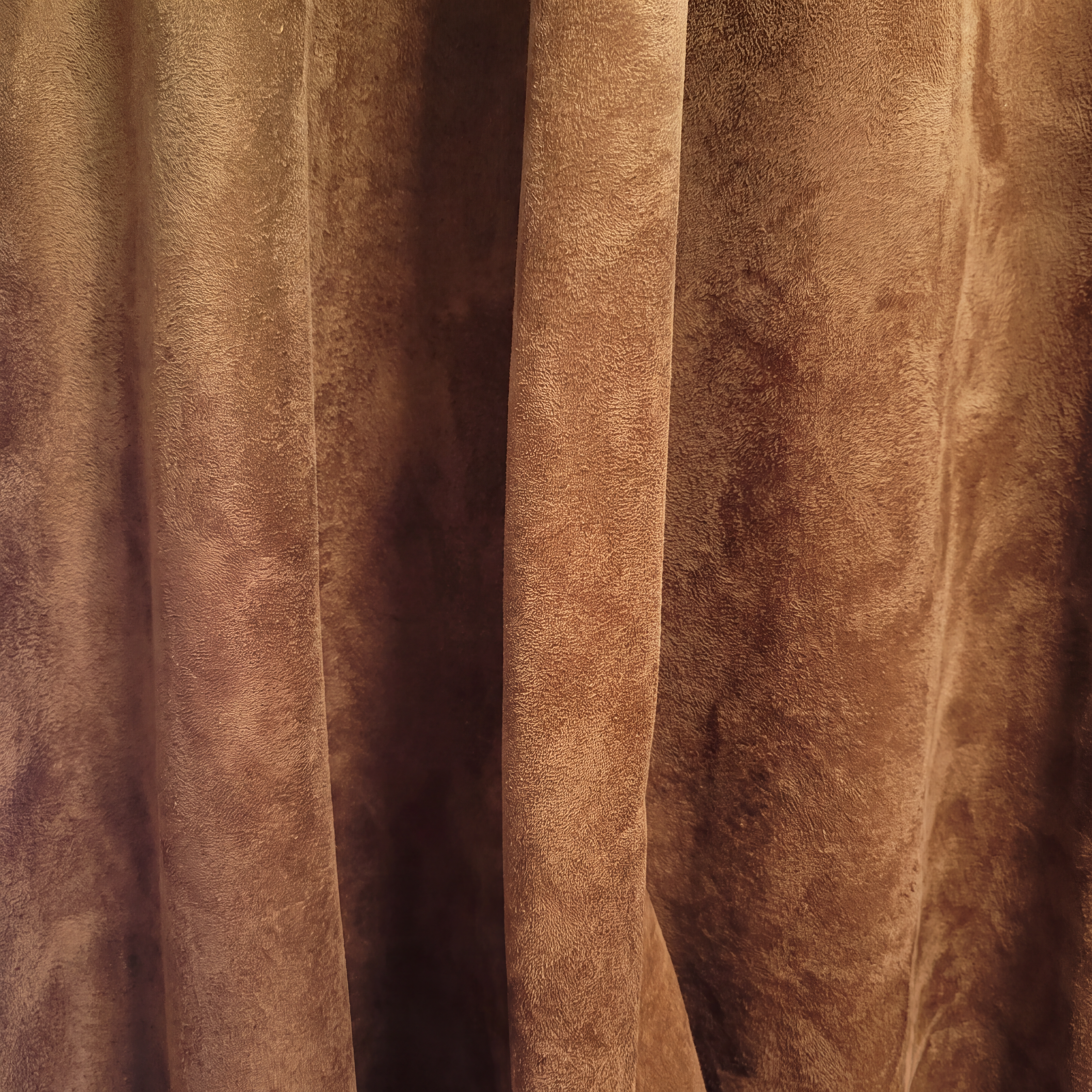 Brown fabric curtain with a soft, textured appearance.