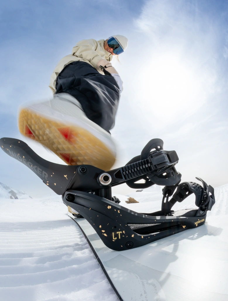 Snowboarder preparing to ride, focusing on the snowboard bindings and boot.