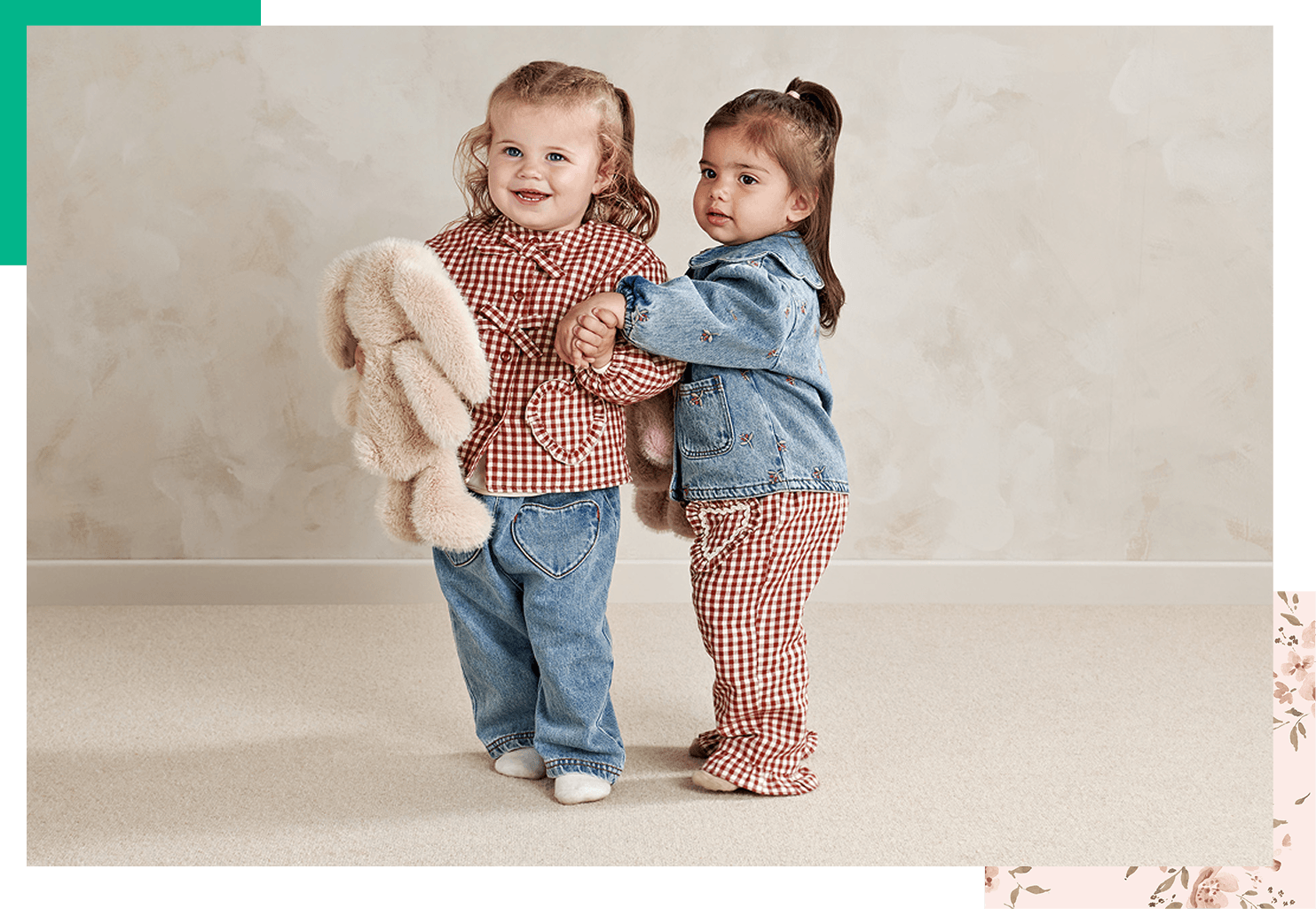 Two young girls in matching outfits, one holding a stuffed animal.
