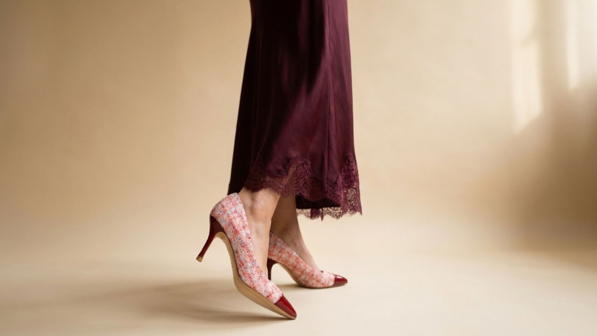 A pair of elegant high-heeled shoes worn with a flowing dress.