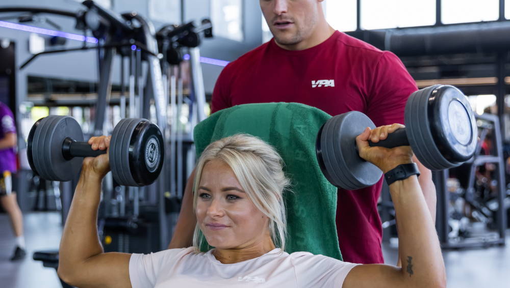 Woman holding heavy dumbbells