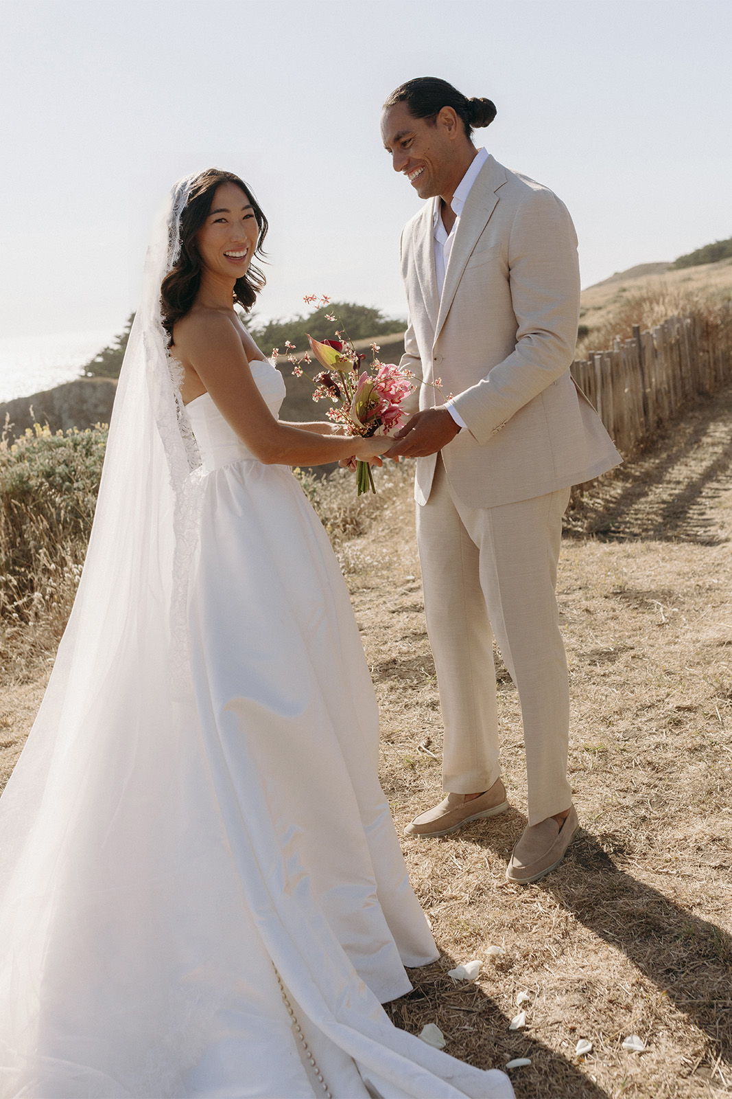 Bride and groom exchanging vows in a scenic outdoor setting.
