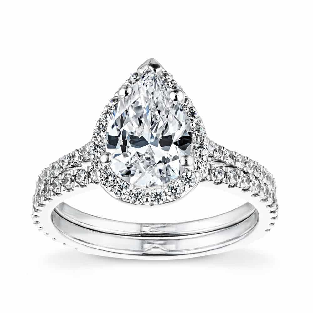Diamond accented wedding ring set featuring diamond halo teardrop engagement ring in white gold
