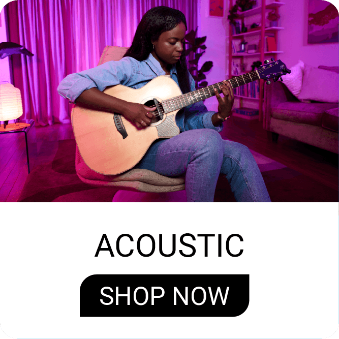 Person playing acoustic guitar in a cozy, brightly lit room.