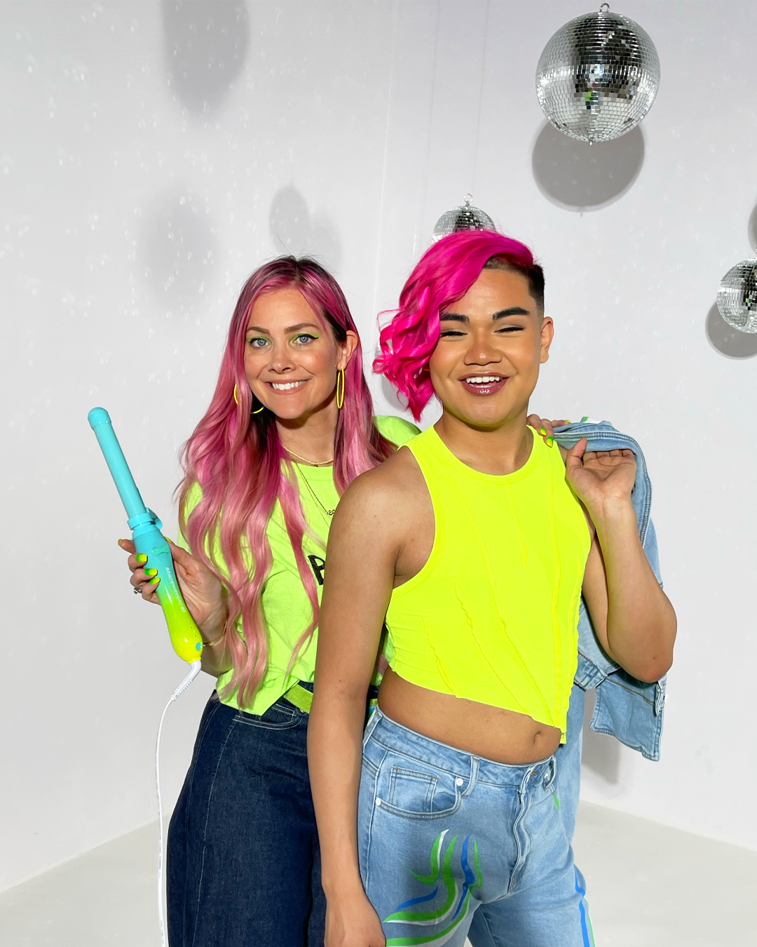 Image of Sarah Potempa and Model in the neon Akira collection  holding up neon B1 Beachwavers