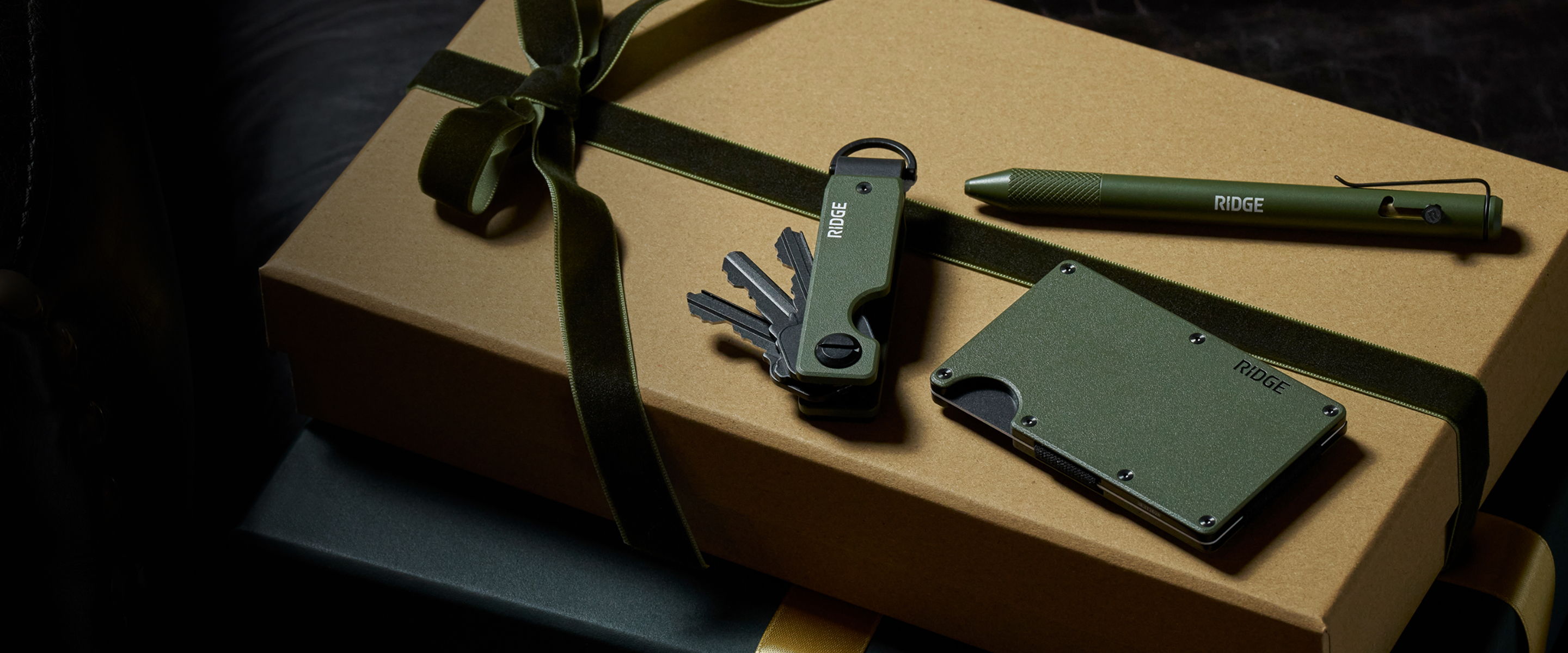 A green-themed gift arrangement with accessories on a brown package.
