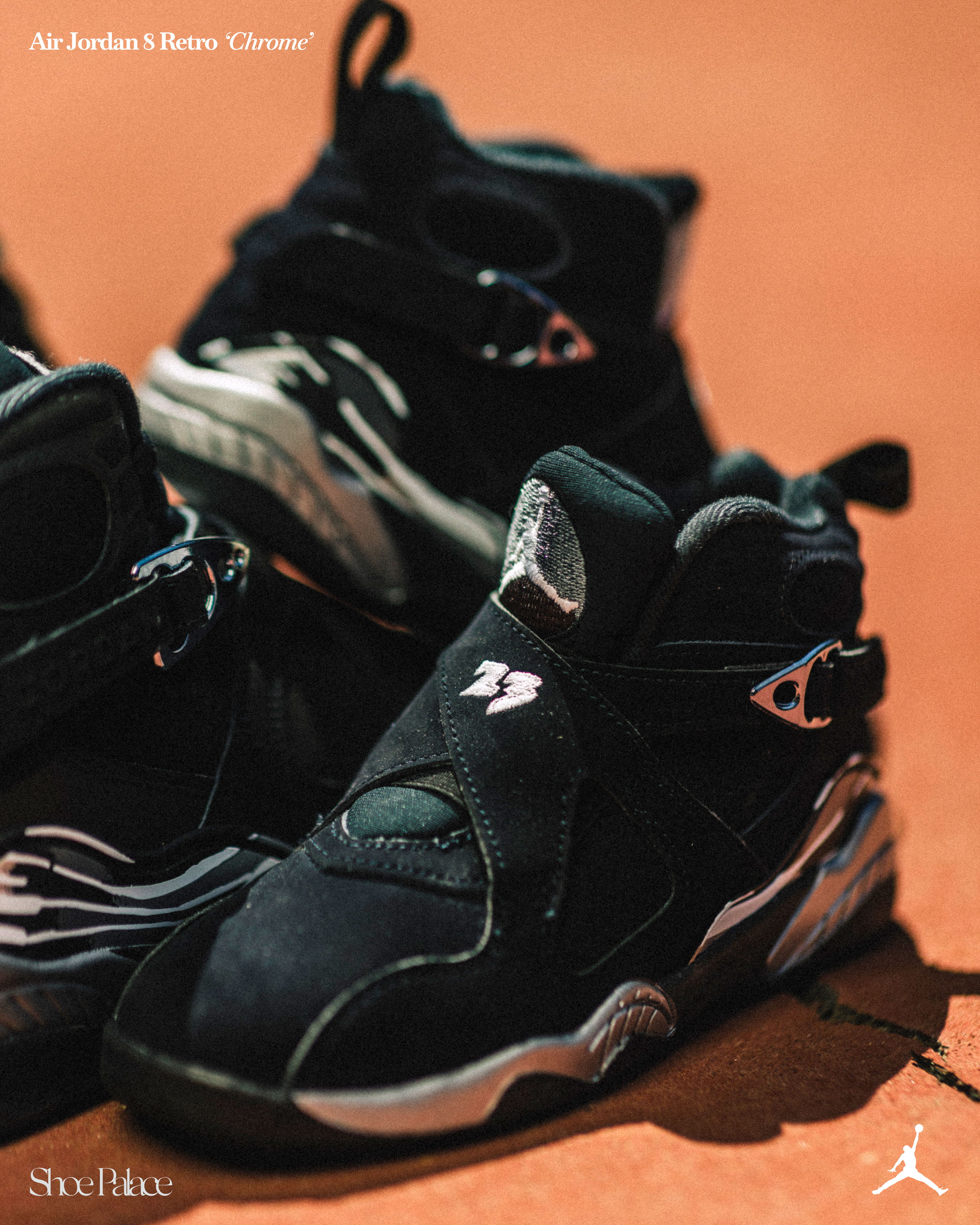 Black Air Jordan 8 sneakers on a court background.