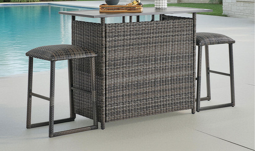 Outdoor bar set with stools near a swimming pool.