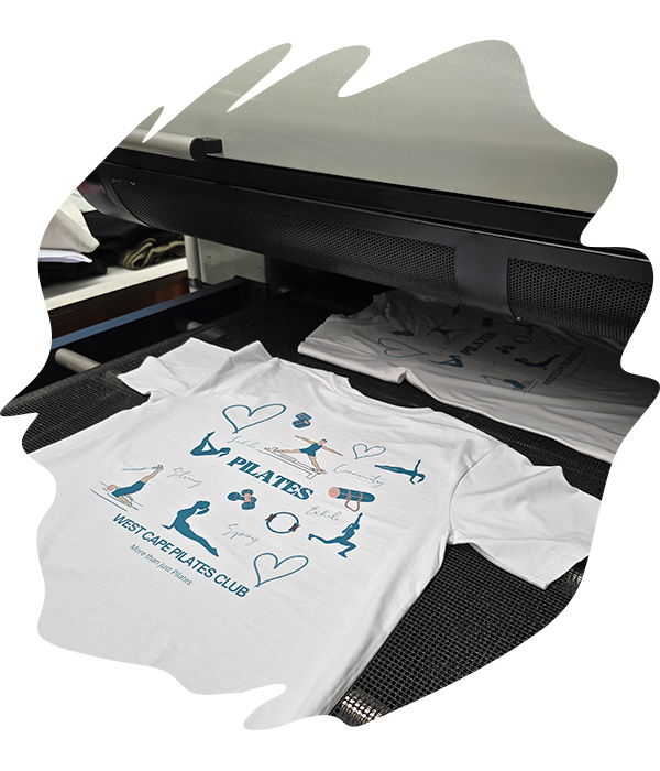 White t-shirts moving through oven conveyor dryer system to heat-set printed designs.